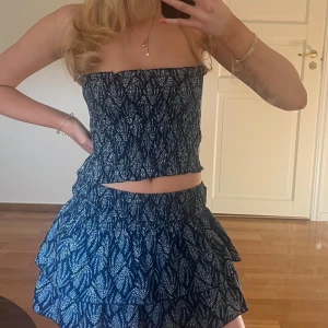 Två delat set - Säljer denna gulliga klänning/kjol/topp från meet me there. Det är blått fjäder-mönster och man kan själva själv hur man vill ha den. Funkar både som kjol/topp och som en klänning! Har ingen prislapp kvar men endast använd en gång!! ☺️☺️