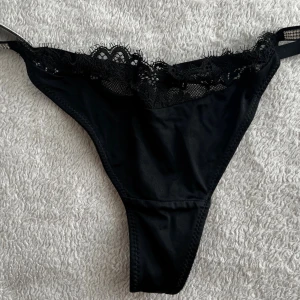 Svarta stringtrosor med spetsdetaljer - Beth Thong. Ny pris 229kr