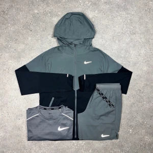 Nike träningsset i grått och svart - Nike Miller – 3-Piece Vanish • T-shirt, shorts & windbreaker i matchande färg • Storlekar från XS till 2XL • Går också att få på activez,se