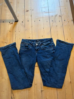 Lågmidjade jeans från LTB - Snygga mörkblå skinny jeans från LTB med klassisk femficksdesign och låg midja. Jeansen har smala ben och är tillverkade i stretchigt denimtyg för en bekväm passform. Perfekta för en trendig och avslappnad look.