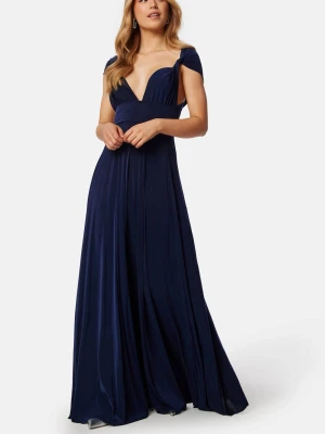 Marinblå balklänning djup v-ringning - Elegant marinblå långklänning med djup v-ringning och korta ärmar. Klänningen har ett flytande fall och markerad midja, perfekt för speciella tillfällen. Tillverkad i ett glansigt material som ger en lyxig känsla.