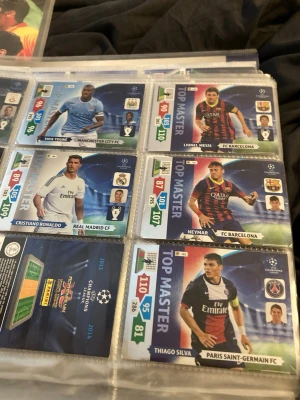 Samling Champions League fotbollskort top master” 2013/2014  - Säljer en samling Champions League fotbollskort i plastficka med spelare som Messi, Ronaldo, Neymar, Thiago Silva och Yaya Touré. Korten har färgstarka designer, klubbmärken och statistik. Perfekt för dig som gillar fotboll och samlarprylar.