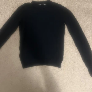 Svart stickad tröja  - Svart stickad tröja från lager 157 i storlek XS. Enkel och stilren design med rund hals och långa ärmar. Perfekt för dig som gillar klassiska plagg med en clean look. Passar dig som vill ha en basic tröja att matcha med allt.