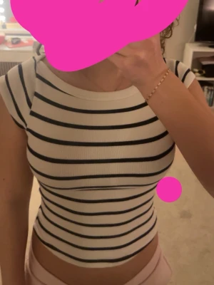 Randig topp från Zara - Vit och svart randig topp från Zara med korta ärmar och rund hals. Tillverkad i mjuk bomull som känns skön mot huden. Perfekt till jeans eller kjol för en enkel och stilren look. Storleken är meduim men kan använt användas på Small som jag är 😊