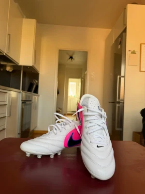 NIKE TIEMPO LIGERA PRO AG ATTACK - VIT/SVART/BLÅ/PINK BLAST - Säljer ett par NIKE TIEMPO LIGERA PRO AG ATTACK från Nike. Endast används en gång men dom var för stora för mig. Storlek 44