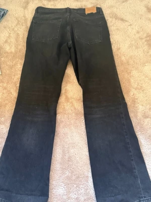 Svarta bootcut jeans  - Säljer ett par mid waist svarta bootcut jeans från Weekday w27 L32