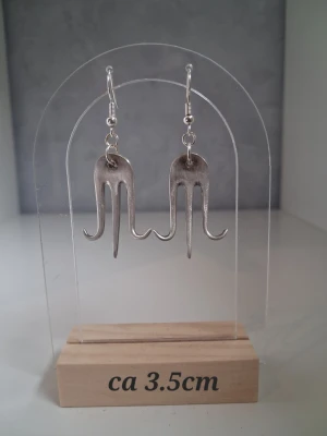 Handgjorda örhängen återbruk nysilver  - Unika silvriga örhängen skapade av 2st gafflar gjorda i nysilver. Ca 3,5 cm långa. Perfekta för dig som gillar statement-smycken med modern känsla. Öronkroken är nickelsäker och aldrig använda 