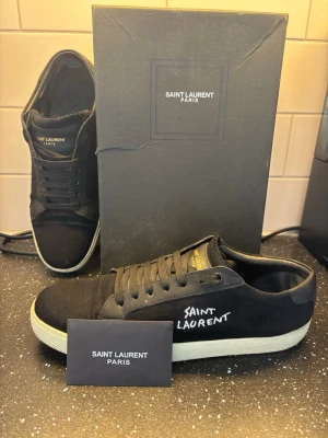 Svarta Saint Laurent Skor - Svarta Saint Laurent skor i storlek 44. Skorna har använts ett par gånger men är i bra skick. Pris kan diskuteras.