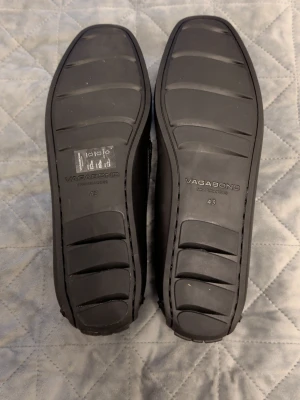 Svarta loafers från Vagabond - Stilrena svarta loafers från Vagabond med klassisk design och fyrkantig tå. Skorna är tillverkade i slätt läder med diskreta sömmar och har en bekväm innersula i beige. Perfekta för dig som gillar en clean och tidlös look.