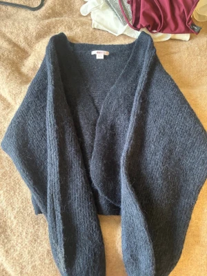 Mörkblå stickad kofta från Gina tricot  - Mysig och oversized mörkblå stickad kofta från gina tricot. Koftan har en öppen front utan knappar och är tillverkad i ett mjukt, fluffigt material som känns lyxigt. Perfekt att slänga på sig över en t-shirt eller blus.