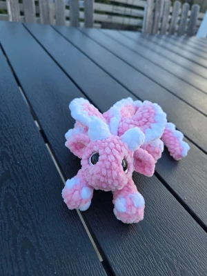 Rosa och vit drakmjukis - Supergullig drakmjukis i rosa och vitt plyschmaterial med stora svarta ögon och mjuka taggar längs ryggen. Perfekt som dekoration eller ge bort i present 💫😍