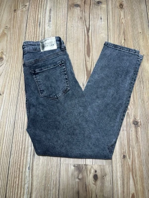Gråa jeans från Tommy Hilfiger - Snygga gråa jeans från Tommy Hilfiger med klassisk femficksdesign och diskret logga på bakfickan. Jeansen har en rak passform och är tillverkade i denim med en tvättad look. Perfekta för en avslappnad och trendig stil. Passar mig (175cm)