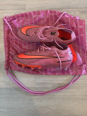 Nike Mercurial rosa fotbollsskor - Säljer ett par Nike Mercurial fotbollsskor i en snygg rosa färg med svarta och orange detaljer. Använda endast 1 gång. Köpte de för runt 3000. Kvitto finns. Vet inte riktigt vad man kan få ut från dem så buda gärna.
