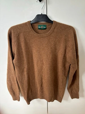 Helt ny finstickad gyllenbrun Alan Paine Lamm ull tröja 48 (M) - Väldigt snygg elegant och populär gyllenbrun Alan Paine lamm ull tröja i storlek M (48) av högsta kvalite säljes. Grym passform inga hål eller fläckar i utmärkt skick som helt ny! Perfekta tröjan nu till sommaren och tveka inte vid minsta fråga eller fundering! Pris ej hugget i sten