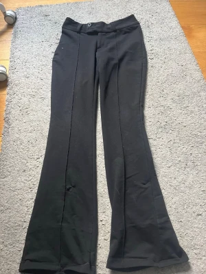 Svarta kostymbyxor  - Säljer ett par svarta kostymbyxor från Gina Tricot i strl 160! Använda en del och har varit uppsydda, därför har de två mindre hål men som är lätta att sy igen om man skulle vilja det!💕 