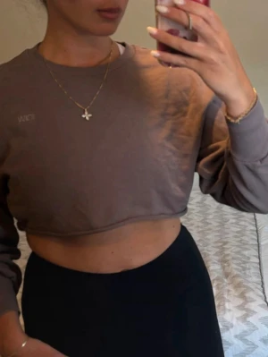 Brun croppad sweatshirt från ICANIWILL - Säljer en brun croppad sweatshirt från ICANIWILL med rund halsringning och långa ärmar. Tröjan har en enkel design utan mönster och är tillverkad i mjuk bomullsmix, perfekt för en avslappnad och trendig look. Kolla min profil för fler plagg! 🥰