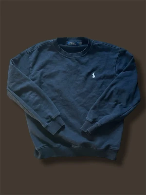 Svart Ralph Lauren tröja - Svart tröja från Polo Ralph Lauren med klassisk rund hals och långärmad design. Storlek L men passar bättre som storlek M 