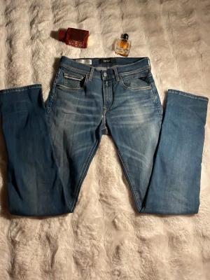 Replay GROVER - Snygga blå jeans från Replay med raka ben och klassisk femficksmodell. Jeansen har ljusa slitningar framtill och bakfickor med dekorativa sömmar. Tillverkade i denim med en skön passform och normal midja. Perfekta för en avslappnad stil. Litet hål i höger knä men de var så när jag köpte dem och det syns inte!🍾🏌️ W28 L32 