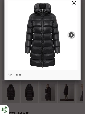 Svart lång dunjacka från Colmar - Snygg svart lång dunjacka från Colmar med huva och quiltad design. Jackan har dragkedja framtill och en stilren look som passar perfekt till kalla vinterdagar. Tillverkad i glansigt material och fylld med dun för extra värme. Pris kan absolut diskuteras!😍har andvänt ungefär 10 gånger eftersom att jag fick den i julklapp, inga defekter osv! Hör gärna av er 