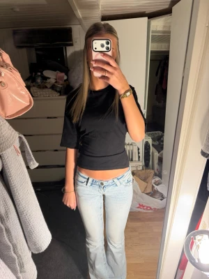 Svart croppad topp med knyt i ryggen - Säljer en svart croppad topp med korta ärmar och öppen rygg som knyts baktill som är från Nelly❤️. Toppen har en slim passform och är perfekt för dig som vill ha en trendig och enkel look. Använd max 3 gånger och därför jag säljer❤️Materialet känns mjukt och stretchigt, troligen bomull eller polyester. Pris kan diskuteras❤️