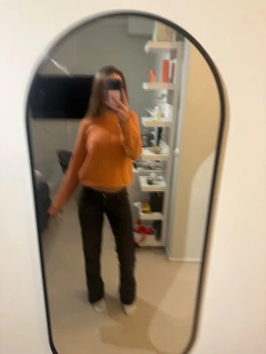 Orange stickad tröja - Jätte fin orange stickad tröja från uniqlo i väldigt skönt material. Aldrig använd förutom på bilden🥰🥰är för 13 år men jag har S och den passar mig jätte bra🥰Nypris 599kr