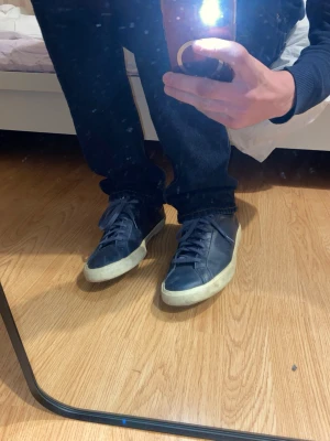 Mörkblå Veja sneakers i läder - Säljer ett par mörkblå sneakers från Veja med klassisk låg profil. Skorna är tillverkade i läder, vilket ger en stilren och tidlös look som fungerar till många olika outfits. Detta är en äldre modell och skorna är väl använda med tydligt slitage. Samtidigt ger slitaget ett snyggt distressed-utseende som passar perfekt för dig som gillar en mer avslappnad stil. Jag tycker skorna passar många outfits men de passade inte mig tyvärr när jag köpte de för ett tag sen. Skriv gärna vid intresse !