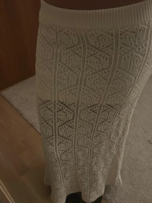 Vit stickad långkjol med spetsmönster - Stickad/virkad kjol! Jättefint skick och aldrig använd😊 obs den är uppsydd och passar till de som är 152-155☺️