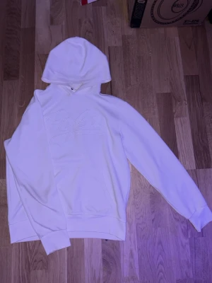 Vit hoodie från Polo Ralph Lauren - Snygg vit hoodie från Polo Ralph Lauren med broderad logga framtill. Klassisk modell med huva och känguruficka. Tillverkad i mjukt material som känns skönt mot huden. Perfekt för en avslappnad och stilren look. Pris kan diskuteras!