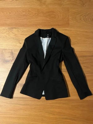 Stilren Svart kavaj från H&M - Klassisk svart kavaj från H&M i storlek 38. Figursydd modell med en knapp framtill! Riktigt stilren och passar lika bra till vardags. Använd 2-3 gånger, pris kan diskuteras vid snabb affär 💕🙌🏼