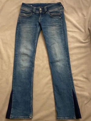 Snygga blå jeans low waist Venus - Snygga blå Lågmidjade jeans ,modell Venus, men utsydda ned till. Extremt snygga jeans som passar till alla lägen! Skulle säga 32 i storlek!