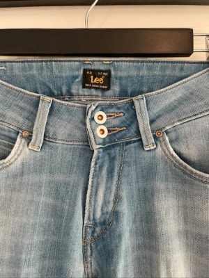 Ljusblå bootcut jeans från Lee - Säljer ett par jättefina ljusblå jeans från Lee då de blivit för små för mig. Storlek är S-M och jag är cirka 170, vilket funkar perfekt. Köpte de för cirka 1000 kr och har aldrig använt! Jeansen sitter verkligen så fint på.