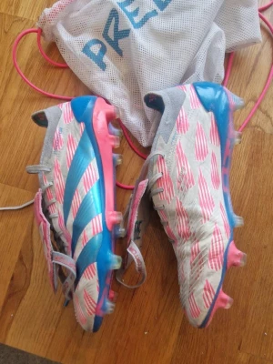 Adidas Predator elite rosa/blå fotbollsskor - Adidas Predator elite fotbollsskor i vitt med rosa och blå detaljer. Elite skobaggen är med i köpet, köptes för 3000 en halv säsong sedan. Bara att höra av sig vid frågor😊