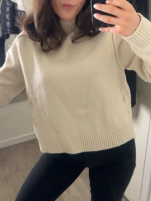 Beige stickad tröja med polokrage - Snygg beige stickad tröja med polokrage och ribbade muddar. Tröjan har en rak passform och är perfekt att matcha med jeans eller kjol. Enkel och stilren design som funkar året runt. Den är också ganska ny har bara haft på mig den två gånger!
