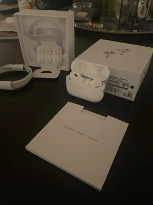 Apple AirPods Pro 2 - Tja säljer mitt par AirPods Pro 2. Hörlurarna har silikonproppar i olika storlekar, brusreducering och levereras med originalkartong, laddkabel och tillbehör. Snygg och stilren design i blankt plastmaterial. OBS laddare ingår ej.