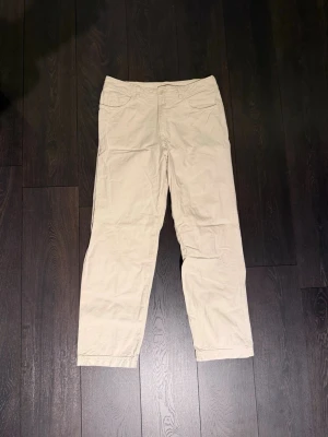 Vita byxor från ARKET - ”Krämvita” byxor från ARKET med raka ben och klassisk femficksdesign. Byxorna är använda endast ett par gånger så skicket är toppen. Perfekta för en avslappnad och stilren look.