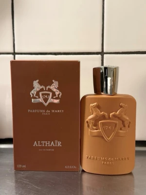 Parfums de Marly Althaïr EdP 125ml - Lyxig parfym från Parfums de Marly, Althaïr, i en snygg matt brun flaska med silverfärgat lock och upphöjt emblem med två hästar. Flaskan rymmer 125 ml och kommer i matchande brun kartong. Perfekt för dig som gillar exklusiva dofter och elegant design.