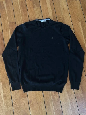 Svart merinoull tröja från J.Lindeberg - Använd 1 gång. 100% merinoull. Tight modell kan även passa S.