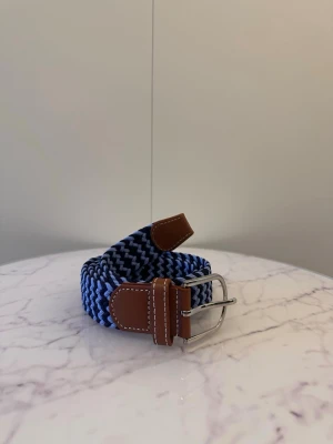 Blått flätat bälte - Tja säljer helt nya svenska klassiska flätade bälten från Bältgallerian i storlek 105cm lång och 3,5cm bred. Dem är i ett elastiskt material och finns i flera olika färger i min profil
