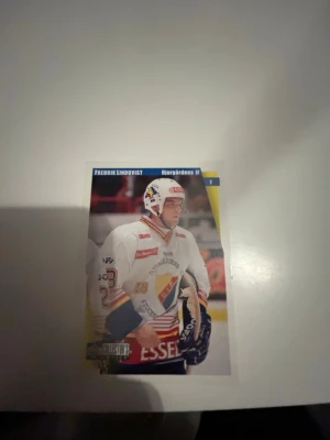 Hockeykort Djurgårdens IF - Fredrik Lindqvist  - Pris går att diskuteras. Säljer ett hockeykort med motiv från Djurgårdens IF. Kortet har färgerna vitt, blått, rött och gult samt detaljer som klubbens logotyp och spelarens namn. Perfekt för samlare av sportmemorabilia eller hockeyentusiaster.