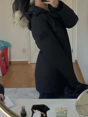 Svart jacka med päls - Jätte fin svart jacka med päls, som inte kommer till användning längre. Jackan har en rak passform, dragkedja och knäppning framtill samt muddar vid ärmsluten. Perfekt för kalla dagar och riktigt snygg till vardagslooken.