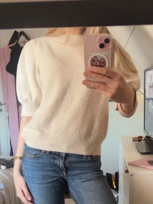 Krämvit puffärm tröja - Säljer en krämvit tröja med puffärmar och ribbade muddar. Tröjan har en rund halsringning och är gjord i ett mjukt material som känns skönt mot huden. Perfekt för dig som gillar en enkel men trendig look.🩷🩷🩷