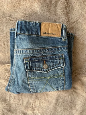 Vintage jeans - PRIS GÅR ATT DISKUTERA. Snygga blå vintage jeans från Lab Industries med klassisk femficksdesign och coola kontrastsömmar på bakfickan. Jeansen har en normal passform och är tillverkade i denim med en läderpatch bak i midjan. Perfekta för en avslappnad och trendig stil. Köpta mellan 1985-2005 så därav går dom inte längre att få tag på💗