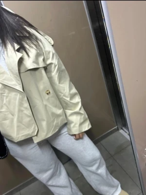 Oversize beige trenchcoat - Trendig oversize trenchcoat i beige med klassiska detaljer som axelklaffar, breda slag och knappar. Jackan har ett bälte i midjan och är tillverkad i ett kraftigt tyg som ger en cool och avslappnad look. Perfekt för lager-på-lager och streetstyle. HELT NYY!!