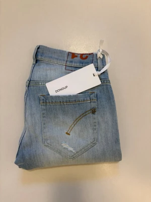 Nya DonDup George jeans - Ljusblåa DonDup George jeans med slitningar//  Helt nya med tagg 10/10 skick //  Nypris: 1795 DKK ca 2600kr //  Storlek 31 //  Mått  Midja bredd 39cm  Längd 102cm  Skriv vid minsta fråga eller fundering🤝