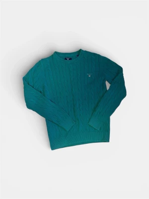  kabelstickad tröja från Gant - Snygg kabelstickad tröja från Gant med rund halsringning och diskret logga broderad på bröstet. Tröjan har långa ärmar och ribbade muddar vid ärmslut och nederkant. Perfekt för dig som gillar klassisk och stilren look.