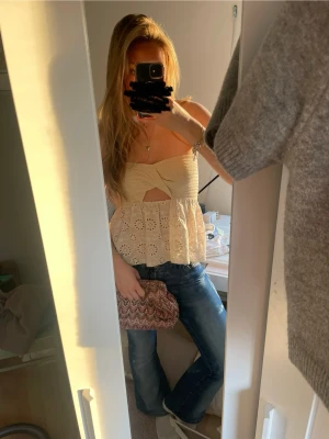 Söt beige broderad linnetopp - Superfin beige linnetopp med broderade blommor och volang nertill. Toppen är ärmlös med smala axelband och har en snygg cut-out detalj framtill. Perfekt för varma dagar och ger en romantisk vibe. I jättefint skick från Zara i st M