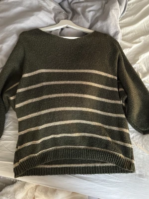 Stickad grön guldig tröja  - Säljer denna jätte fina stickade olivgröna tröjan med guldiga detaljer. Super mysig men används inte längre. Stl M, köpt på Åhléns