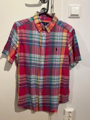 Ralph Lauren skjorta Nyskick - Rutig Ralph Lauren skjorta som endast är använd en gång. Det är barnstorlek men den passar om man är cirka 170 cm eller har XS i storlek.