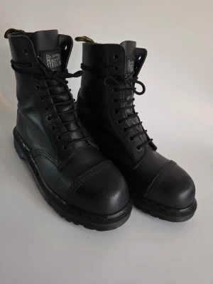 🦇 Vintage Dr. Martens 10-hål • Stålhätta • Made in England 🦇 - Grymma svarta vintage-docs i läder med 10 hål och stålhätta (steel toe). Äkta MIE = otroligt mycket bättre kvalitet än de nyare modellerna! 🦇 ​• Storlek: EU 38 / UK 5 • Skick: Bra och inkört vintage-skick. Det finns några märken och spår av användning, titta noga på bilderna!  ​Hör av dig om du har frågor! 🖤