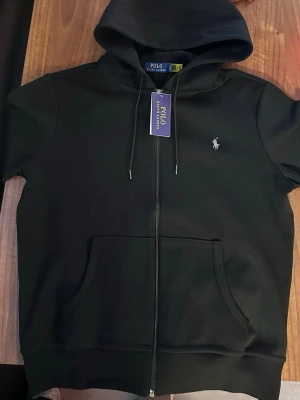 Svart hoodie från Polo Ralph Lauren - Svart Ralph Lauren hoodie, helt ny och i perfekt skick med lapparna fortfarande på.